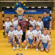 Die E-Jugend-Mannschaft des TB Pforzheim feiert ihren Turniersieg beim SWP-Cup 2025 in der Fritz-Erler-Halle – mit Pokal, Maskottchen und Trainerin.